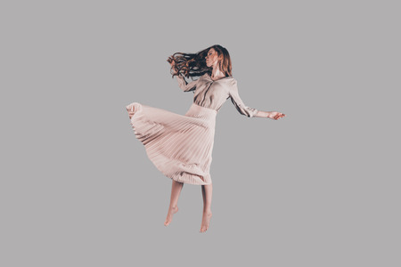 Hovering beauty. Studio shot of attractive young woman hovering in airの写真素材