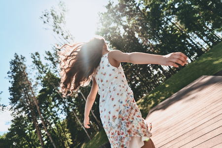 Rear view of little girl running while spending time outdoorsの写真素材
