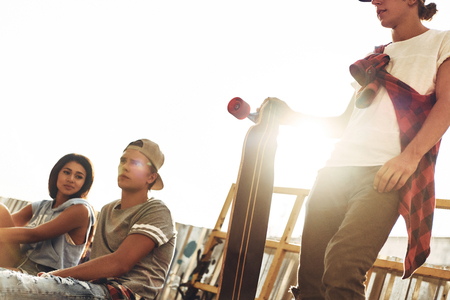 Life filled with friendship. Group of young modern people hanging out together while spending time at the skate park outdoorsの写真素材