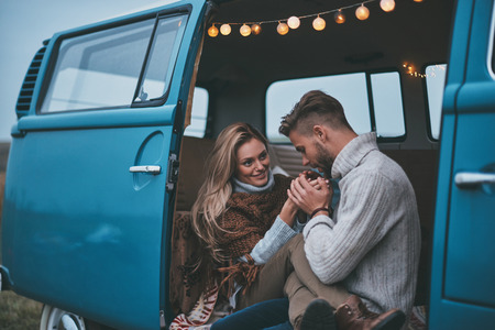 So gentle!  Handsome young man warming up his girlfriends hands while enjoying their road travelの写真素材