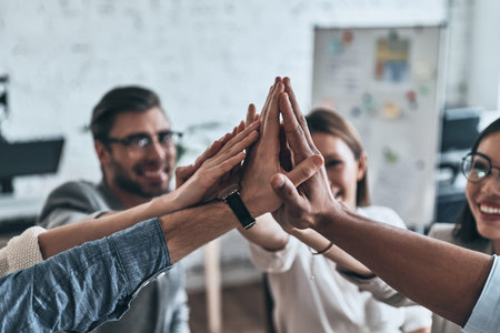 High-five! Top view of business colleagues giving each other high-five in a symbol of unity and...