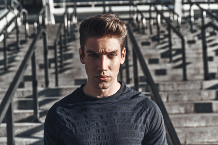 Towards a healthier lifestyle. Serious young man in sports clothing looking at camera while standing...