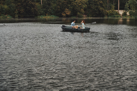 Stress free zone. Beautiful young couple having romantic date while rowing a boatの写真素材