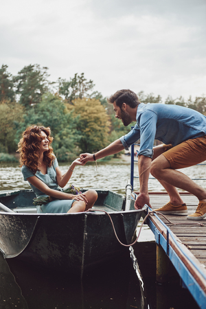 Best way to spend the date. Happy young couple getting ready to row a boat while enjoying their date outdoorsの写真素材