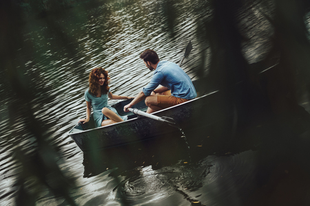 In the perfect place. Beautiful young couple enjoying romantic date while rowing a boatの写真素材