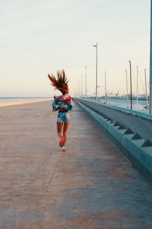 Making effort. Full length rear view of beautiful young woman in sports clothing running while...