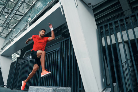 Full length of athletic young woman in sports clothing hovering in a long jump while exercising...
