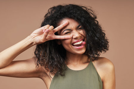 Beautiful young African woman in casual clothing smiling and gesturing