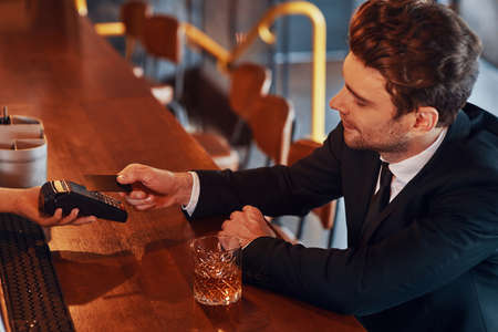 Top view of handsome young businessman making a contactless paymentの写真素材