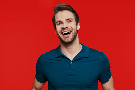 Portrait of handsome young man in casual wear looking at camera and smiling