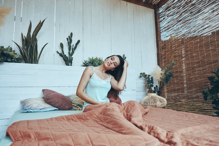 Beautiful young smiling woman smiling while waking up in the morningの写真素材