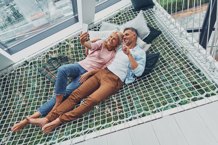 Top view of beautiful mature couple making selfie by smart phone and smiling