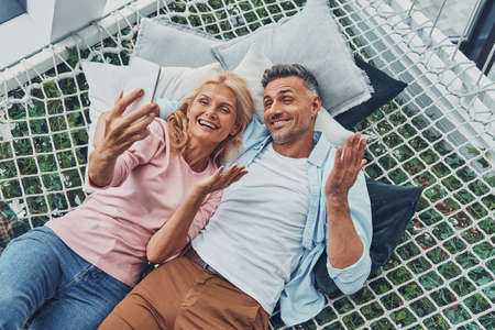 Top view of beautiful mature couple making selfie by smart phone and smilingの写真素材
