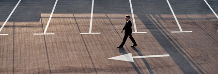 Top view of man in formalwear moving forward with arrow sign on the roadの写真素材