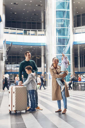Full length of family with two little kids waiting for their flight at the airport terminalの写真素材