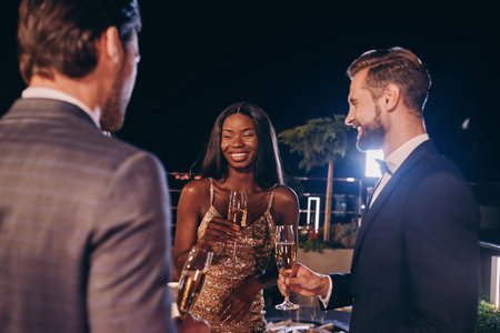 Group of people in formalwear communicating and smiling while spending time on luxury party