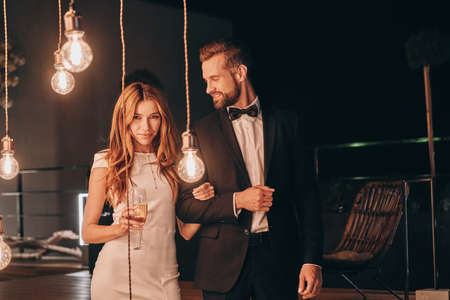 Beautiful young couple in formalwear spending time on night partyの写真素材