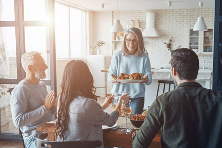 Modern multi-generation family smiling while having dinner togetherの写真素材