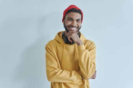Handsome African man keeping arms crossed and smiling while standing against the wallの写真素材