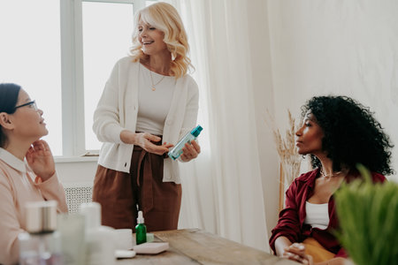 Three confident mature women smiling while examining beauty products togetherの写真素材