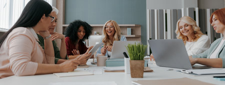 Group of confident mature women discussing business while having meeting in the officeの写真素材