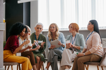 Group of confident mature women examining beauty products during specialized conferenceの写真素材