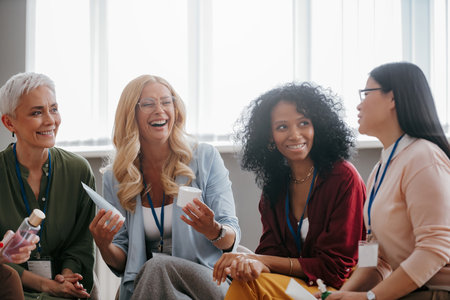 Group of happy mature women discussing beauty products during specialized conferenceの写真素材
