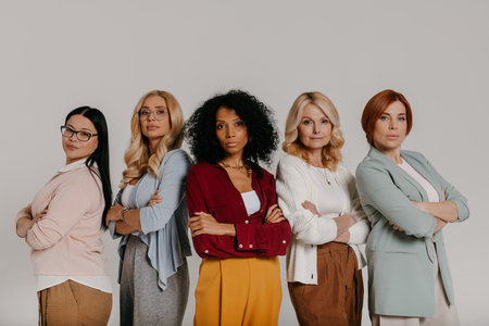 Multi-ethnic group of confident mature women looking at camera against grey backgroundの写真素材