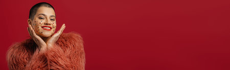 Happy young short hair woman with shiny crystals over her face gesturing against red background