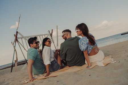 Four young friends talking and smiling while spending carefree time seaside