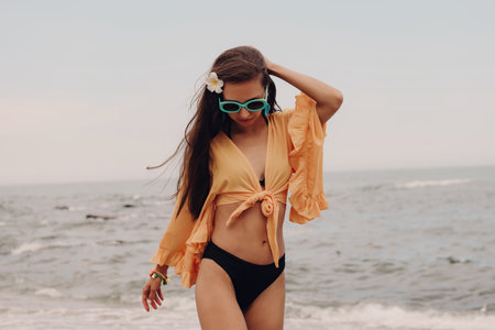 Beautiful young woman in boho styled crop top enjoying summer day on the beachの写真素材