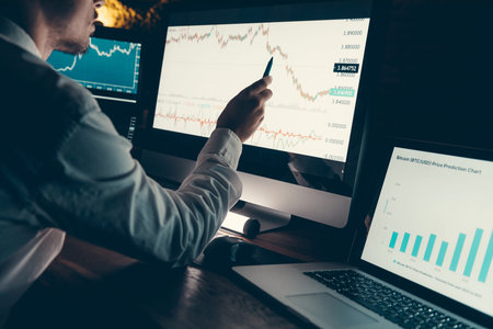 Close-up of male financial broker pointing computer monitor while analyzing stock market graph