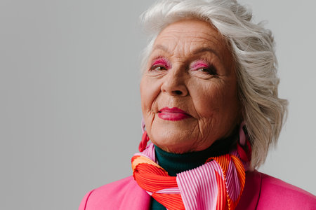Elegant elderly woman with make-up wearing fashionable clothing and radiating self-loveの写真素材