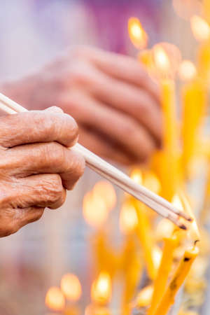 People are lighting incense stick to pray for goodnessの写真素材