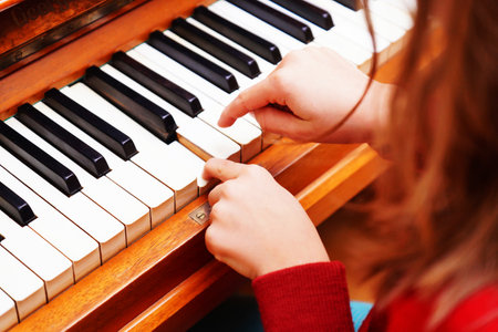 Child's hand presses the piano keysの写真素材