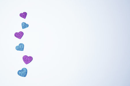 Glittering blue and lilac hearts on white background. Valentines day concept. women's day. copyspace. flat lay.の写真素材
