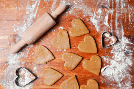 Heart cookies out dough, rolling pin and molds on table with flour. Valentine's Day celebration. home baking.の写真素材