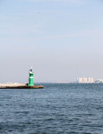 Green colored lighthouse that built at the entrance of harbour の写真素材