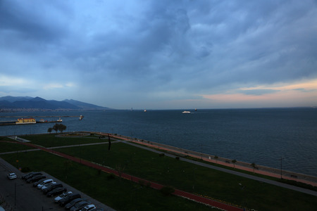 Konak, Izmir, Turkey â March 31, 2017: On a nice afternoon people were walking next to coast in Izmir, Turkey. Ships were parked near to city. Izmir is a city which located on Mediterranean Sea.のeditorial素材