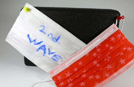 Covid-19 second wave message. Black colored yoga block and red protective mask shot together.の写真素材