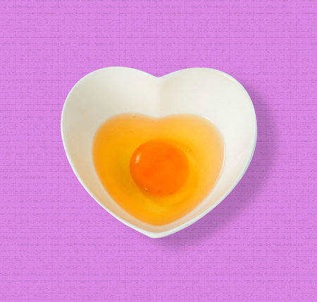 Raw egg in a cup on pick  backgroundの写真素材