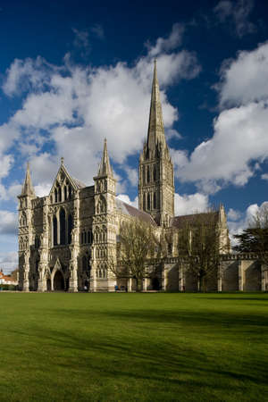 View of Salisbury Cathedral in England with blue sky and white cloudsの写真素材