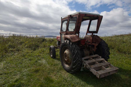 Rusty old red tractor by the sea in South Uist in the Outer Hebridesの写真素材