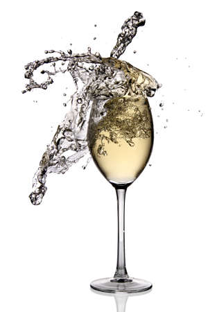 White wine splashing out of glassの写真素材