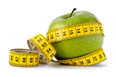 Green apple with measuring tape on white backgroundの写真素材