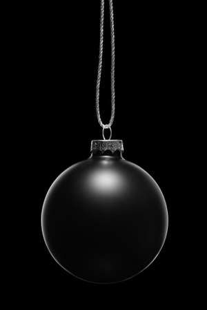 Hanging black Christmas ornament on a black background. Low key.の写真素材