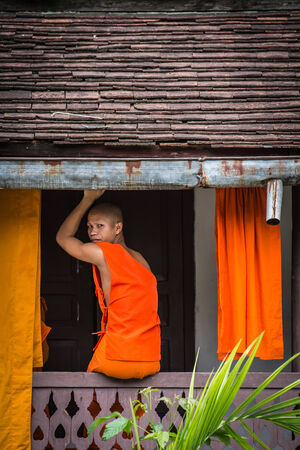 LUANG PRABANG, LAOS - August 11: Unidentified monk in Wat Xieng Thong pagoda on August 11, 2014, in Luang Prabang, Laos. About 60% of the population of Laos practice Theravada Buddhism.のeditorial素材
