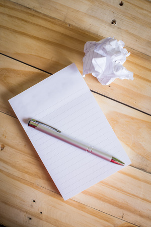 Blank notepad and pen on wooden tableの写真素材