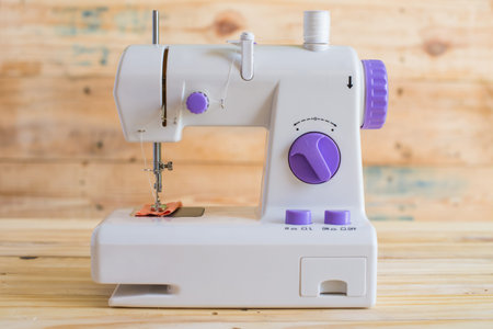 Modern sewing machine on wood table