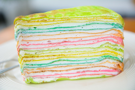 Delicious rainbow cake on plate on tableの写真素材
